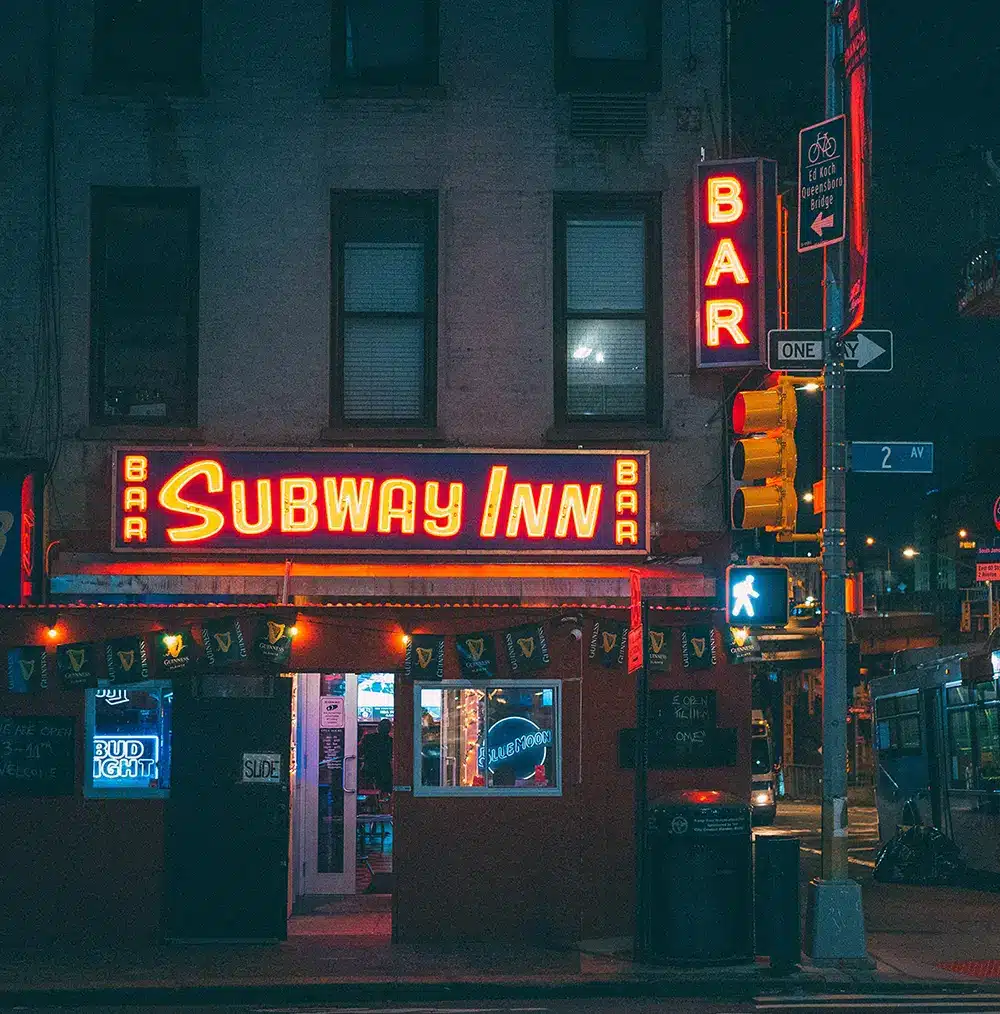 eine leuchtreklame die im dunkeln an einer Straße leuchtet "Subway Inn"